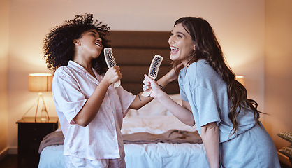 Image showing Friends, singing with brush and women in bedroom to get ready for girls night out dancing, fun music concert and happiness. Girl, friend and happy smile, girlfriends grooming at sleepover in pajamas.