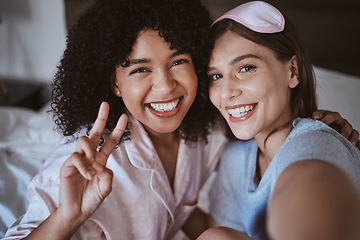 Image showing Friends, selfie and smile, women on bed in pajamas with bonding, peace sign and happy face. Social media, girl and influencer in portrait picture, sharing memory and friendship at bedroom sleepover.