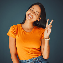 Image showing Happy woman with smile, peace hand sign and Gen z youth, freedom and fashion isolated on studio background. Happiness, mindset and v emoji, beauty with young person, eyes closed and care free