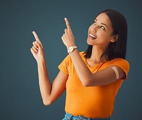 Image showing Woman, hands and pointing in studio for covid, vaccine and healthcare with mockup, space and grey background. Health, girl and model with plaster for corona, shot and immunity or isolated copy space