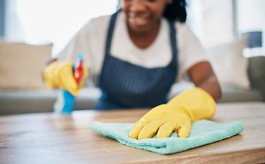 Image showing Hand, cloth and gloves with a black woman cleaning a home for hygiene as a housekeeper or maid. Furniture, bacteria and chemical with a female cleaner working in housekeeping in an apartment