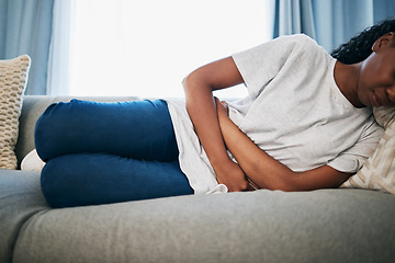 Image showing Period, stomach ache and black woman with pain on sofa holding belly from sickness, cramps and digestion. Menstruation, endometriosis and girl on couch with menstrual problem, pms and bloated abdomen
