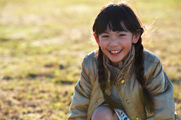 Image showing Portrait, Asian girl and playing in park, smile and carefree on holiday, summer and freedom. Young person, female child and kid with happiness, play game or on field for fun, relax and break on grass