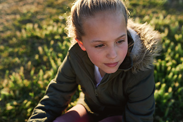 Image showing Nature, summer and girl sitting on the grass in a park after playing alone on vacation or weekend trip. Natural, beautiful and child having fun and enjoying in an outdoor field on holiday in Canada.