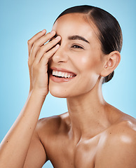 Image showing Skincare, wellness and happy woman in a studio for a cosmetic, health and natural face routine. Self care, happiness and excited female model with a facial skin treatment isolated by blue background.