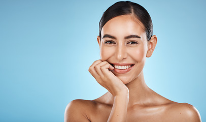 Image showing Skincare, beauty and portrait of a woman in a studio with a cosmetic, facial and natural routine. Health, wellness and happy female model with a skin treatment by a blue background with mockup space.