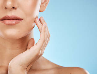 Image showing Half, face and woman for skincare, beauty and touching isolated on a blue background in a studio. Mockup, cosmetics and facial check of a model feeling skin for acne, problem and eczema on a backdrop