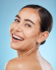 Image showing Portrait, smile and happy with a model woman in studio on a blue background for beauty or skincare. Face, skin and cosmetics with an attractive young female posing to promote a luxury product