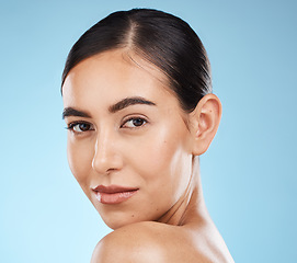 Image showing Portrait, beauty and skincare with a model woman in studio on a blue background for natural treatment. Face, skin and cosmetics with an attractive young female posing to promote a luxury product