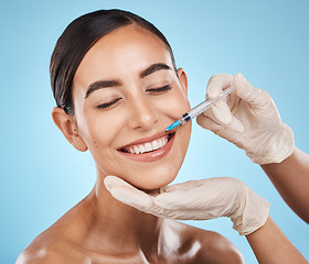 Image showing Filler, woman and plastic surgery on lips with needle, skincare or beauty clinic in studio. Botox, face injection and aesthetic cosmetics for happy transformation, change and smile on blue background