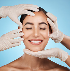 Image showing Plastic surgery, beauty and woman in a studio for a skincare, natural and cosmetic facial treatment. Cosmetics, self love and surgeon hands on a female model face for consultation by blue background.