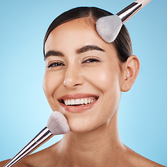 Image showing Face portrait, beauty and makeup brush of woman in studio isolated on blue background. Aesthetics, facial treatment or skincare of happy female model with brushes for foundation, powder or cosmetics.