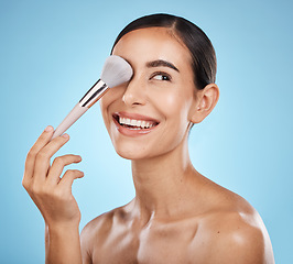 Image showing Beauty, face and makeup brush of woman in studio isolated on a blue background. Thinking, facial treatment and skincare aesthetic of happy female model with tools for foundation, powder or cosmetics