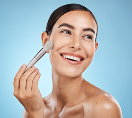 Image showing Cosmetics, thinking and woman with a brush for makeup isolated on a blue background in studio. Skincare, beauty and model happy about cosmetology, foundation and body health on backdrop with a smile