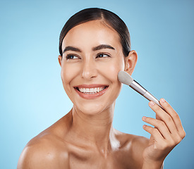 Image showing Cosmetics, happy and woman with a brush for makeup isolated on a blue background in a studio. Skincare, beauty and model thinking of cosmetology, foundation and body health on a backdrop with a smile