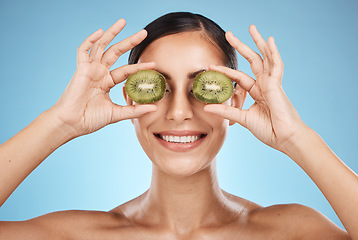 Image showing Beauty, skin care and woman with kiwi fruit face for dermatology, natural cosmetic and wellness. Aesthetic model person for sustainable facial glow, nutrition diet and healthy smile blue background