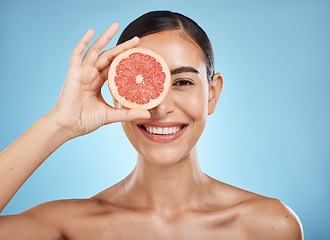 Image showing Beauty, skin care and woman portrait with grapefruit face for dermatology, natural cosmetic and wellness. Happy aesthetic model for sustainable fruit facial, nutrition and glow on blue background