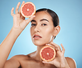 Image showing Face, portrait and skincare of woman with grapefruit in studio isolated on a blue background. Organic cosmetics, food and female model with fruits for nutrition, healthy diet or vitamin c for beauty.