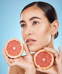 Image showing Face, beauty and skincare of woman with grapefruit in studio isolated on a blue background. Organic cosmetics, food and female model thinking about fruits for nutrition, healthy diet or vitamin c.