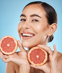 Image showing Face, skincare and portrait of woman with grapefruit in studio isolated on a blue background. Organic cosmetics, food and female model with fruits for nutrition, healthy diet or vitamin c for beauty.