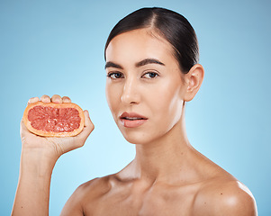 Image showing Face, beauty and grapefruit squeeze woman portrait for dermatology, natural cosmetic and wellness. Aesthetic model person for vitamin c fruit facial glow, nutrition diet and skin care blue background