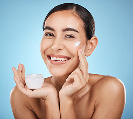 Image showing Face cream, skincare portrait and woman with product in studio isolated on a blue background. Cosmetics, dermatology and happy female model with lotion, creme or moisturizer for beauty and wellness.