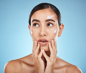 Image showing Beauty cream, skin care and face of a woman with hands for dermatology, cosmetics and natural glow. Aesthetic model person with secret spa facial lotion for health and wellness on a blue background