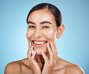 Image showing Face cream, skincare portrait and woman in studio isolated on a blue background. Cosmetics, dermatology and happy female model apply lotion, creme or moisturizer for beauty, aesthetics and wellness.