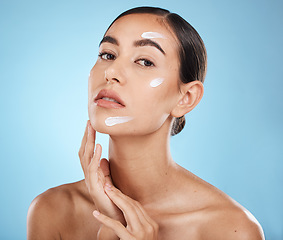 Image showing Skincare cream, face portrait and woman in studio isolated on a blue background. Cosmetics, dermatology and young female model with lotion, creme or moisturizer for beauty, aesthetics and wellness.