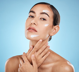 Image showing Face portrait, skincare cream and woman in studio isolated on a blue background. Cosmetics, dermatology and young female model with lotion, creme or moisturizer for beauty, aesthetics and wellness.