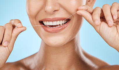 Image showing Woman floss teeth zoom, smile and dental healthcare, fresh breath and mouth cleaning isolated on blue background. Face, hands and happy with oral hygiene product, healthy gums and flossing in studio