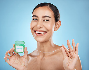 Image showing Woman, floss and smile in portrait with dental healthcare, fresh breath and teeth cleaning isolated on blue background. Face, happy and oral hygiene product, mouth health with healthy gums in studio