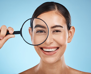 Image showing Face portrait, magnifying glass and skincare of woman in studio isolated on a blue background. Beauty search, makeup and cosmetics of female model with magnifier lens to check aesthetic wellness.