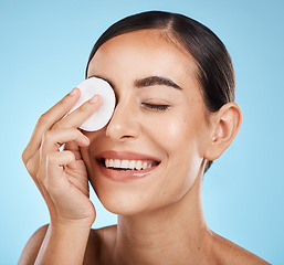 Image showing Cotton, skincare and woman isolated on studio background for face, eye makeup and facial cleaning product. Happy model or person smile with beauty glow and using a cosmetics remover for self care