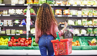 Image showing Black woman, shopping groceries and vegetables in store with flowers on sale choice, discount or valentines promotion. Young female person, vegan food or decide by shelf for product in grocery basket