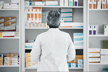 Image showing Stock, back and pharmacist at a medicine shelf for healthcare, medical work and service at a pharmacy. Doctor, pills and pharmaceutical worker looking at the coice of drugs while working at a clinic