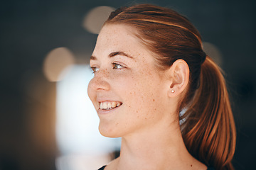 Image showing Face, freckles and thinking with a redhead woman indoor feeling happy or positive about the future. Idea, ginger and carefree with an attractive young female standing alone on a dark background