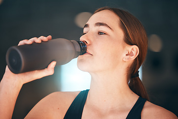 Image showing Fitness, hydration and female athlete drinking water for thirst, wellness and health in a training studio. Sports, energy and young woman enjoying a healthy cold beverage after a workout or exercise.