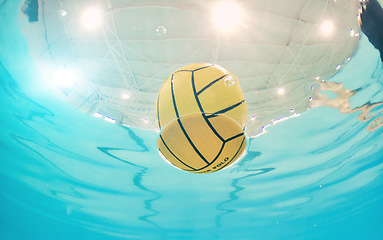 Image showing Water polo, sports and ball in a pool from below with equipment floating on the surface during a competitive game. Fitness, training and exercise while a still life object floats during a match