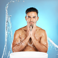 Image showing Water splash, face and man with basin for beauty, skin and skincare cleaning body and topless. Mexican, male and wellness model with moisture, cleanse and hydration isolated in studio blue background