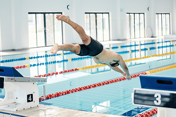 Image showing Sports, swimming pool and man diving in water for training, exercise and workout for competition. Fitness, wellness and professional male athlete in action for dive, jump and race from diving board