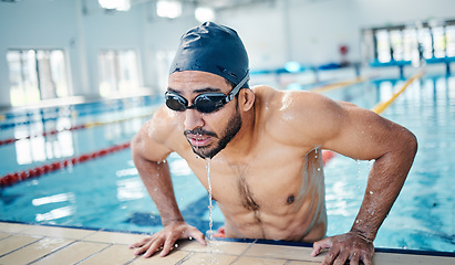 Image showing Athletic, breathing and man swimming for fitness, training and race in a stadium pool. Tired, sports and face of an athlete swimmer doing cardio in the water for a workout, sport and competition