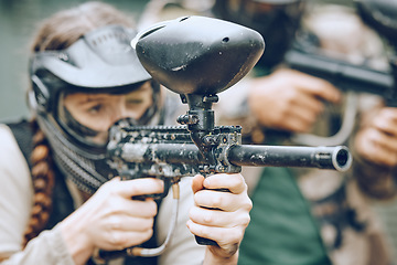 Image showing Paintball, sports and woman aim with gun for shooting ready for games, arena match and battlefield in woods. Adrenaline exercise, adventure and girl with weapon in camouflage, action and safety gear