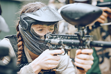 Image showing Paintball, gun and woman with helmet aim for shooting ready for game, arena match and battlefield. Extreme sports, military adventure and girl with weapon in camouflage, action and safety gear