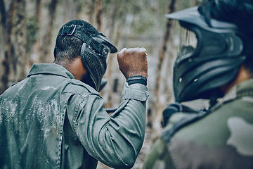 Image showing Hand sign, man and paintball training by friends for planning, strategy and plan of action outdoor. Military, men and fist of guy leading team in sports, shooting and intense target practice together