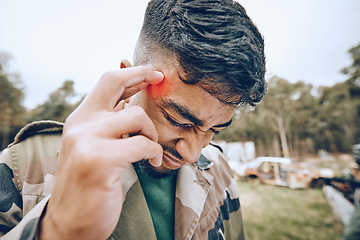 Image showing Paintball, headache and pain by man on a field with a sports injury, fitness and training outdoor. Head, problem and temple of guy with issue, arthritis or accident during exercise, drill or match
