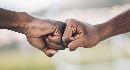 Image showing Fist bump, closeup and hands celebrating as teamwork on sports field winning and power of working together. Team, support and unity of teammates in collaboration or partnership with motivation