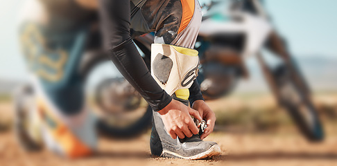 Image showing Start, motorcycle and man tying laces in nature for adventure, holiday and race in the countryside. Road, travel and biker ready with shoes for a journey on a motorbike on a dirt road for freedom