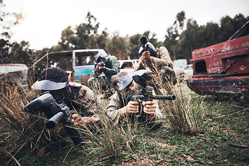 Image showing Paintball, team and camouflage waiting in grass for sneak attack, aim or practice with guns. Group of soldiers in extreme sports, teamwork or coordination in hiding for strategic plan to win match