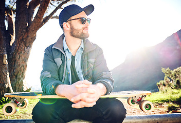Image showing Skateboard, sports and man thinking on mountain for adventure, freedom and ready for skateboarding. Urban fashion, fitness and profile of skater with board for exercise, skating and training outdoors